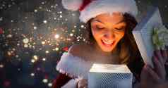 兴奋圣诞老人女人开放神奇的圣诞节礼物盒子闪闪发光的光