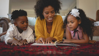 非洲美国妈妈。可爱的孩子们说谎地板上阅<strong>读故事</strong>书