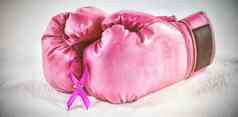 特写镜头粉红色的乳房癌症意识丝带拳击手套