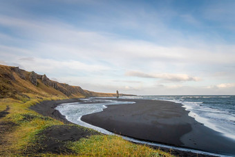 白色棚子岩石形成冰岛火山列站黑色的海滩杂草丛生的悬崖