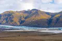 瓦特纳霍库尔冰川冰岛深蓝色的冰前面杂草丛生的山