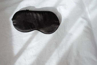 丝绸黑色的睡眠面具登记白色弄皱的表前视图平躺水平复制痉挛概念休息觉醒睡眠社会媒体博客最小的风格