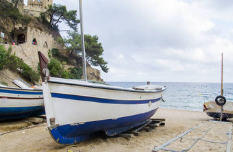 钓鱼船弓蓝色的天空海海滩背景海滩船海岸略雷特三月美丽的夏天一天地中海海背景科斯塔布拉瓦加泰罗尼亚西班牙