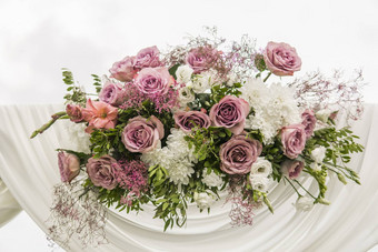 花木拱白色布新鲜的紫罗兰色的粉红色的白色花绿色叶子乡村婚礼仪式