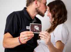 快乐结婚了夫妇显示怀孕测试坚持超声波图片未出生的婴儿焦点条纹