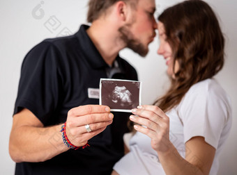 快乐结婚了夫妇显示怀孕测试坚持超声波图片未出生的婴儿焦点条纹