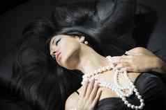 美丽的女人珍珠项链耳环沙发