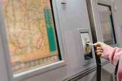 女人手插入卡买地铁火车票机