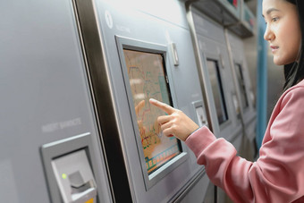 女人选择目的地地铁火车票机