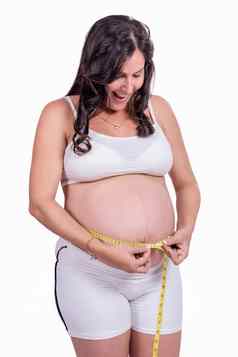 怀孕了女人测量日益增长的肚子