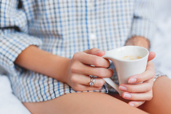 女人衬衫坐着床上杯热咖啡明亮的订婚婚礼环闪耀手指舒适的早....首页