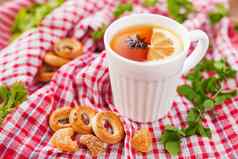 杯热茶柠檬茴香明星白色杯子热饮料格子红色的毛巾姜块饼干