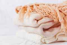 桩米色羊毛衣服白色背景温暖的针织毛衣围巾折叠堆