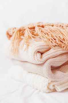 桩米色羊毛衣服白色背景温暖的针织毛衣围巾折叠堆模仿新浪微博风格语气