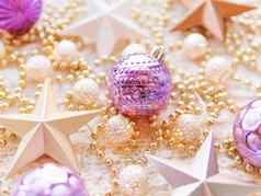 圣诞节一年明星装饰白色针织背景金属光灯泡精致的模式金珠子紫罗兰色的球