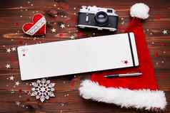 圣诞节一年背景成形相机红色的圣诞老人的他记事本笔圣诞节装饰星星银闪闪发光的雪花五彩纸屑木表格的地方文本