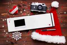 圣诞节一年背景成形相机红色的圣诞老人的他记事本笔空照片框架圣诞节装饰星星银闪闪发光的雪花五彩纸屑木表格的地方文本