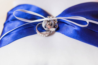 一对金婚礼环几何点缀枕头蓝色的弓丝带象征爱婚姻