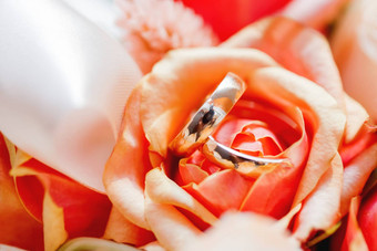 金婚礼环谎言内部橙色玫瑰花花束象征爱婚姻
