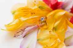 一对婚礼订婚环色彩斑斓的alstroemeria花自然背景象征爱婚姻关闭