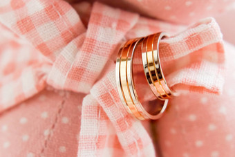 金婚礼环粉红色的格子织物婚礼珠宝细节