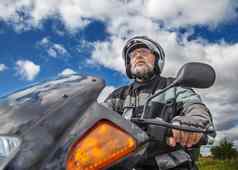 上了年纪的骑摩托车的人穿夹克眼镜头盔