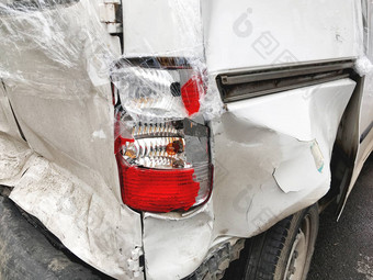 车事故破碎的保险杠头灯白色车凹痕覆盖塑料包装