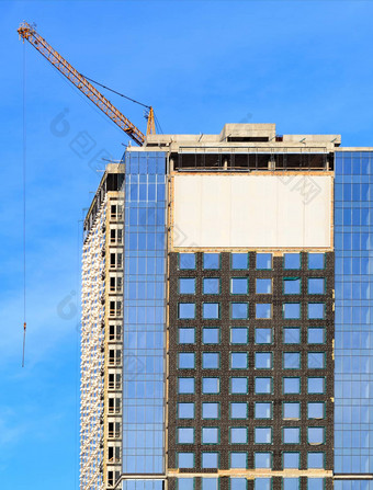 建设现代混凝土建筑玻璃外观反射蓝色的天空塔起重机