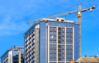 玻璃外观蓝色的天空起重机现代混凝土建筑建设改造区