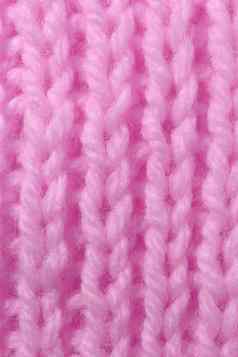 粉红色的羊毛针织纹理垂直编织用钩针编织详细的行毛衣纺织背景宏特写镜头