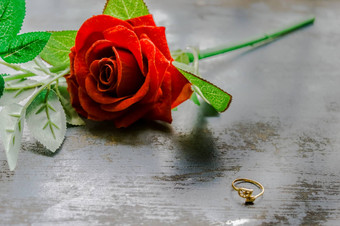 关闭黄金订婚环Jewelery乡村金属地板上软焦点浪漫的红色的玫瑰花背景爱建议提出概念情人节一天婚礼假期复制空间