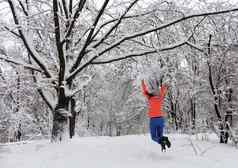 年轻的美丽的女孩走幸福的跳跃冬天白雪覆盖的童话语言森林多枝的常年橡木