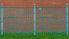 阿卡蓝色的波浪栅栏建草丛里区域红色的砖墙