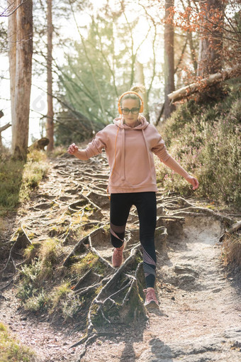 活跃的运动女人运行秋天秋天森林跳根路径健康的生活方式图像年轻的活跃的高加索人女人慢跑自然