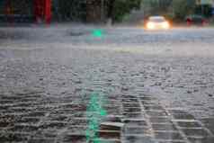 重雨十字路口绿色光交通光反映了大滴流水城市街