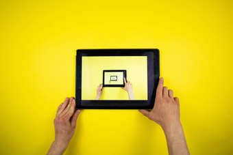 平板电脑手黄色的背景图片图片