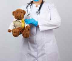 儿科医生白色外套蓝色的乳胶手套持有棕色（的）泰德