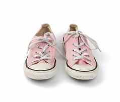 一对光粉红色的穿纺织运动鞋鞋带孤立的
