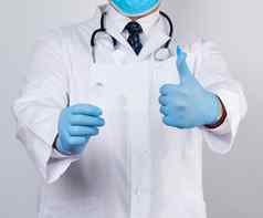医生白色医疗外套蓝色的橡胶手套持有