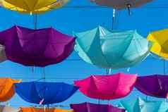 色彩斑斓的充满活力的雨伞挂走街