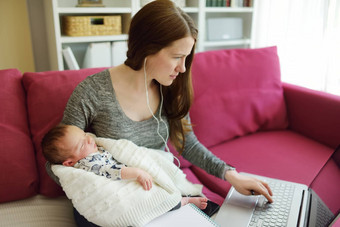 年轻的妈妈作品远程首页办公室新生儿婴儿自由职业者女人持有婴儿移动PC工作场所生活房间工作检疫