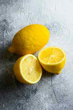 美味的切片柑橘类水果黄色的柠檬柠檬减少一半前视图复制空间新鲜的柑橘类水果维生素源灰色背景
