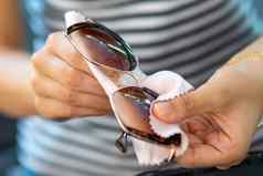 擦拭太阳镜女人清洁太阳眼镜微纤维