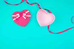 开放粉红色的心形的礼物盒子弓蓝色的背景
