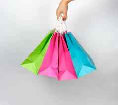 女手持有彩色的纸购物包装袋