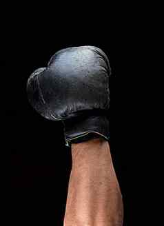 人类手黑色的皮革拳击手套提高了