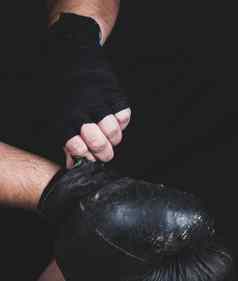 运动员把黑色的皮革拳击手套