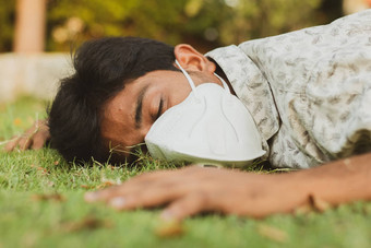 生病的年轻的男人。下降了地面医疗脸面具概念显示生病的头晕生病了健康脱水太阳中风