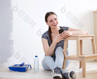 女人坐着地板上采取打破绘画首页移动电话