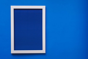 空白色框架蓝色的模式纹理皱巴巴的纸体积水平行挂蓝色的墙